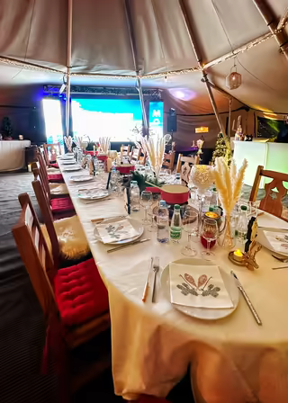 Long table set for a group dinner inside a heated tipi