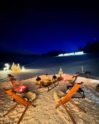 Birthday evening in the snow: deck chairs, lit trees and reindeer figures