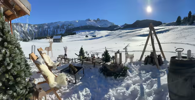 Deck chairs with sheepskins and wooden reindeer on the snow, facing the 3 Vallées