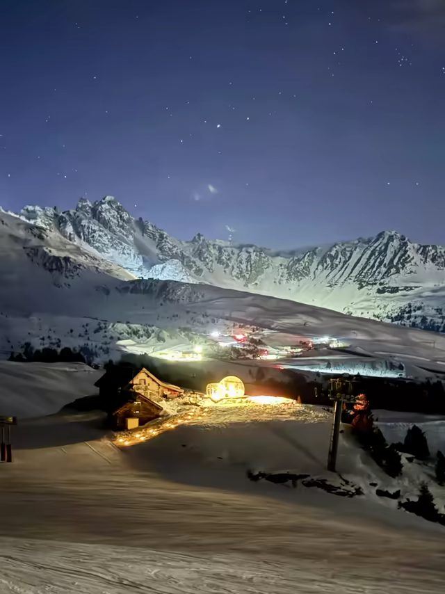 Lit chalet and bubble at the foot of a ski slope, at night in the 3 Vallées