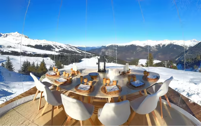 Round table set inside a transparent bubble, on a sunny day in the 3 Vallées