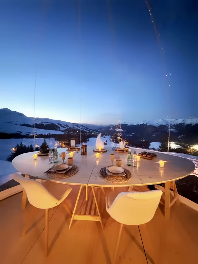 Table for four inside a transparent bubble, the mountains at blue hour