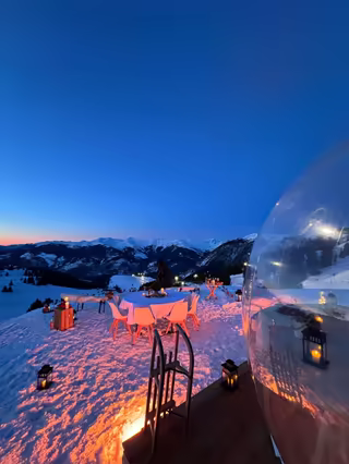 Transparent bubbles and a table under pink light, the mountains at blue hour